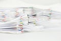 Pile paperwork of report with colorful paperclip on white table