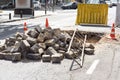 Pile of paving stones dug out of a hole under asphalt in the process of repairing the road. Royalty Free Stock Photo