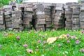 A pile of paving tiles on the field with flowers