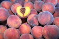 A pile of peaches and one peach, cut in half Royalty Free Stock Photo