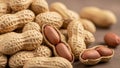 A pile of peanuts with some shells cracked open on brown surface Royalty Free Stock Photo