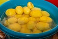 A pile of peeled raw potatoes in a large blue bowl of water Royalty Free Stock Photo