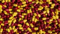 Pile of pills background, pill capsules in yellow and red. drug or vitamin capsules