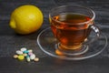 A pile of pills with a cup of tea and lemon Royalty Free Stock Photo