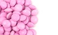 Pile of Pink Candy Coated Chocolate Gems on a White Background