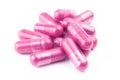 Pile of pink organic capsules isolated on white background closeup with selective focus Royalty Free Stock Photo