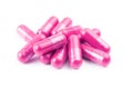 Pile of pink organic capsules isolated on white background closeup with selective focus Royalty Free Stock Photo