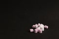 Pile of pink and white small marshmallows on a black surface Royalty Free Stock Photo