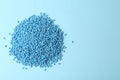 Pile of plastic granules on light blue background, top view. Space for text Royalty Free Stock Photo