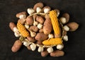 A pile of potatoes, corn cobs and garlic, still life on a dark wooden background Royalty Free Stock Photo