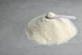 Pile of protein powder, scoop and space for text on grey background Royalty Free Stock Photo