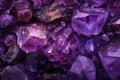 Pile of purple raw amethyst crystals on rocks natural wallpaper background