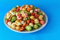 A rainbow of sweet popcorn in a plate on a blue background Royalty Free Stock Photo