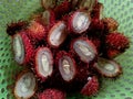 a pile of rambutan fruit that has been cut in half in a green container Royalty Free Stock Photo