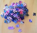 Multi colored puzzle pieces on a wooden surface Royalty Free Stock Photo