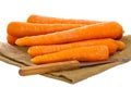 Pile of raw carrots on a burlap on a white background