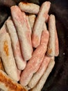 Pile of raw and half cooked chipolata sausages Royalty Free Stock Photo