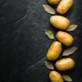 A pile of raw potatoes on a dark stone background. Preparation of soup or potato dishes.