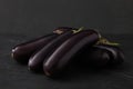 Pile of raw ripe eggplants on black table Royalty Free Stock Photo