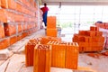 Pile of red blocks on wooden platform, worker build wall with bricks and mortar Royalty Free Stock Photo