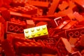 Pile of red color building blocks with selective focus and highlight on one particular yellow block using available light Royalty Free Stock Photo