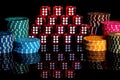 Pile of red dice and stack of casino chips on isolated black background. Pyramid of dice with number six and colored
