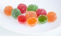 A pile of red, green and yellow jelly cubes on a white plate on a white background Royalty Free Stock Photo