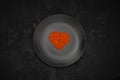 Pile red lentil in shape of heart isolated on black background. Royalty Free Stock Photo