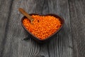 Pile red lentil in shape of heart isolated on wooden background. Top view. Flat lay. Royalty Free Stock Photo