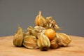 Pile of ripe physalis fruits on a wooden table. Close up studio shot, front view