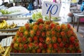 Pile of ripe sweet reddish rambutan fruit with pliable green hair in local market atmosphere Royalty Free Stock Photo