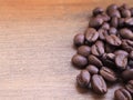 A pile roasted coffee beans on wooden background. Royalty Free Stock Photo