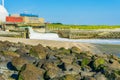 Pile of rocks on the beach viewing on a waterfall and industry Royalty Free Stock Photo