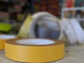 A pile of rolls of masking tapes and sellotape on a table