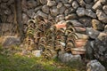 A pile of roofing tiles lying in front of a stone wall