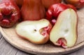 A pile of rose apples with a slice in a wooden tray on the table Royalty Free Stock Photo