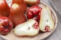 A pile of rose apples with a slice in a wooden tray on the table Royalty Free Stock Photo