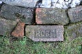 Pile of Rose brand name bricks repurposed as lawn edging
