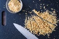 Pile of rough chopped walnuts on a black cutting board, fine chopped walnuts in glass bowl, chef knife Royalty Free Stock Photo