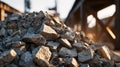 Pile of rough grey construction stones on a building site with blurred industrial structure and warm sunlight in the background Royalty Free Stock Photo