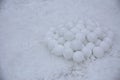 A pile of round snowballs for a game of children molded from snow against a background of loose snow. March 2018 Ukraine.