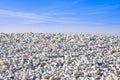 Pile of rounded white stones against a blue sky