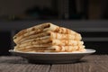Pile of russian pancakes in plate against dark background