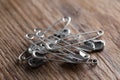 Pile of safety pins on wooden table, closeup Royalty Free Stock Photo