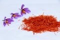 A pile of saffron stamens and crocus flowers on a white background. Drying spices, use in cooking.