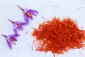 A pile of saffron stamens and crocus flowers on a white background. Drying spices, use in cooking.