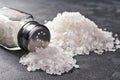 Pile of salt and salt shaker on black stone background. Close-up Royalty Free Stock Photo