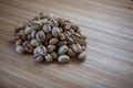 Pile of salted pistachios. Wooden table background.