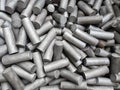 A pile of sand blasted stainless steel rods - closeup with selective focus