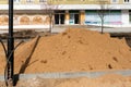 A pile of sand on the construction site. Repair of sidewalks and roadways in the city. Replacement and repair of lighting poles